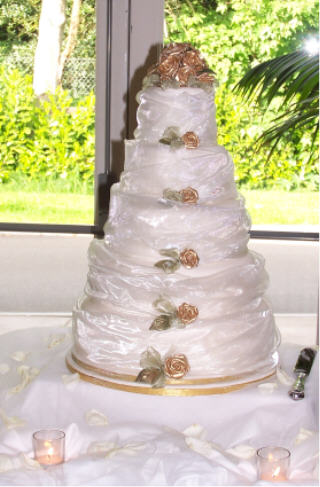 Exquisite five tier wedding cake swathed in masses of silk organza and